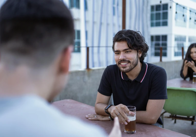 the man sits in front of a table full of people