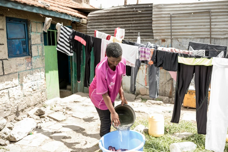 a person in pink shirt holding a blue bucket