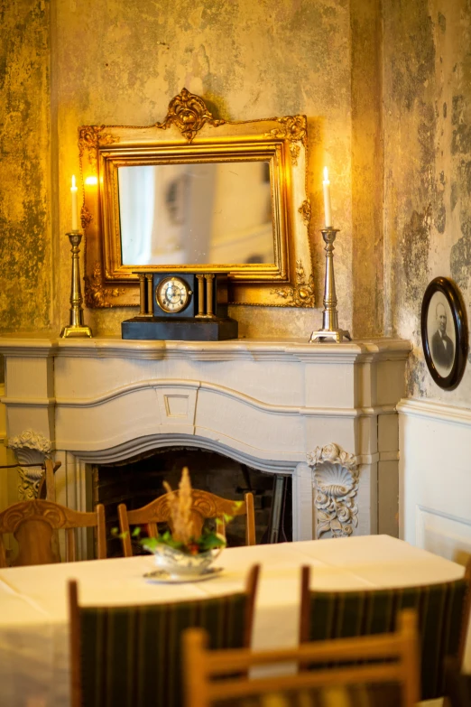 a small table in front of a fireplace with chairs around it