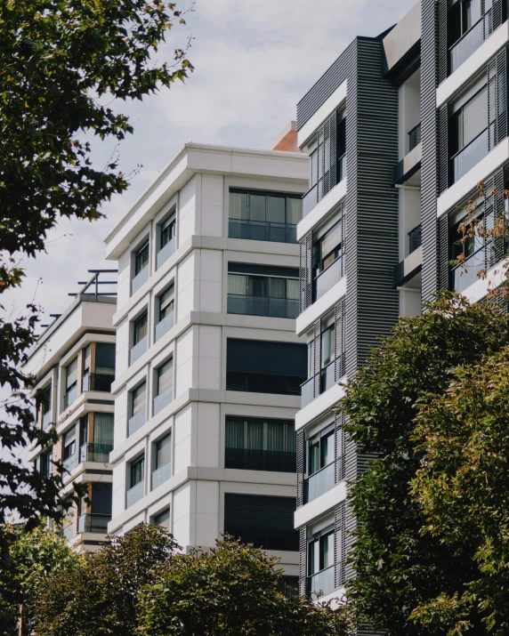 a building with large windows near trees and buildings