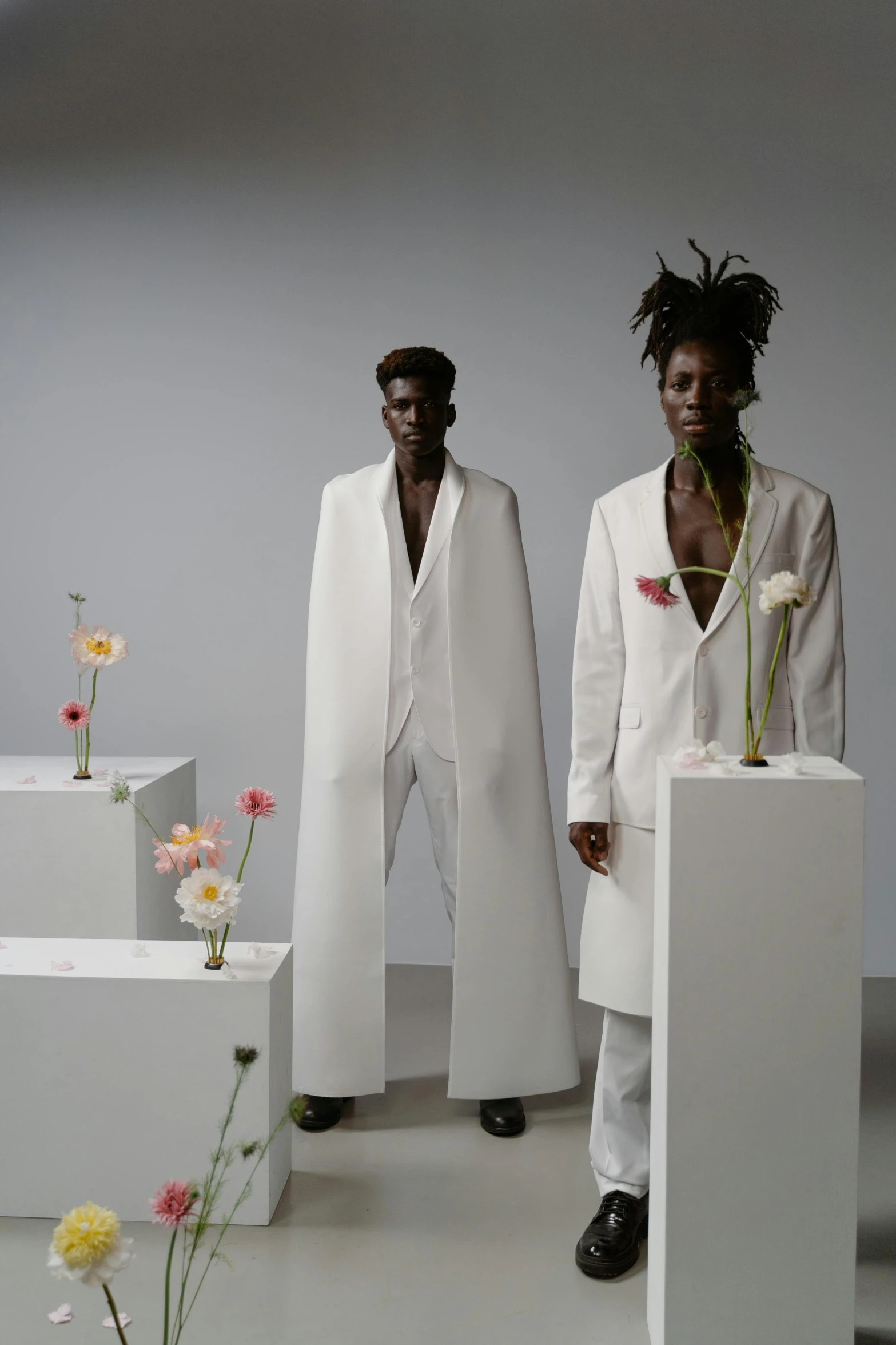 a couple of people are standing next to a plant