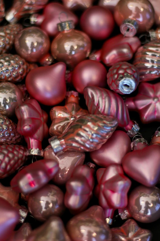 a pile of shiny red hearts with other decorations