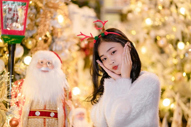 a little girl standing next to santa claus