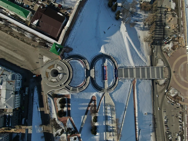 aerial view of city with railroad tracks in front of buildings and snow