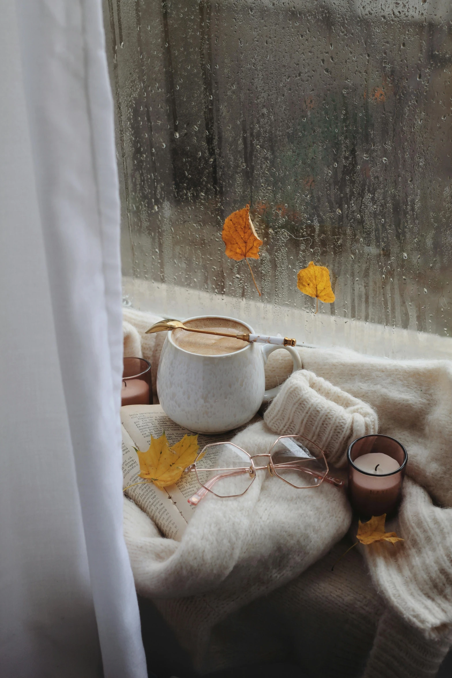 a cup of coffee is sitting next to some leaves