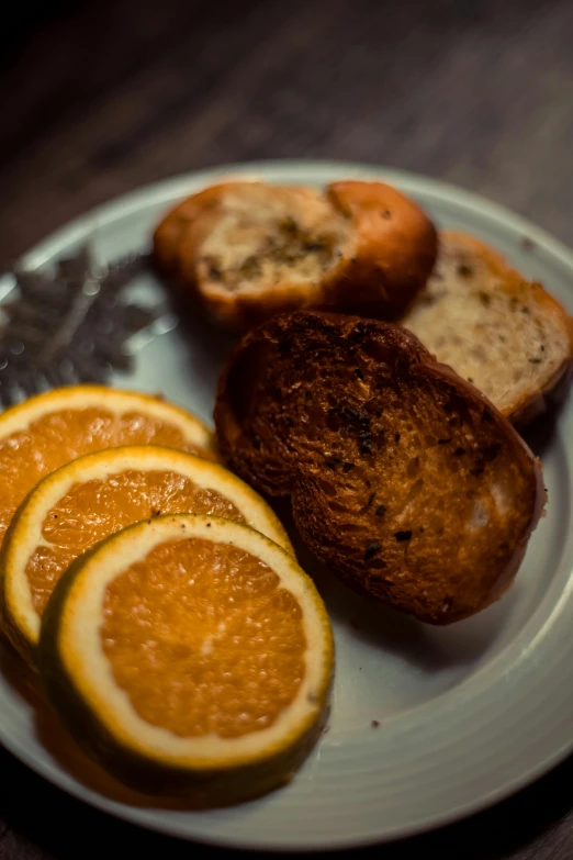 four pieces of bread and four slices of orange are on a plate