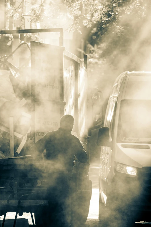 people are standing in front of smoke coming out from the back of a truck