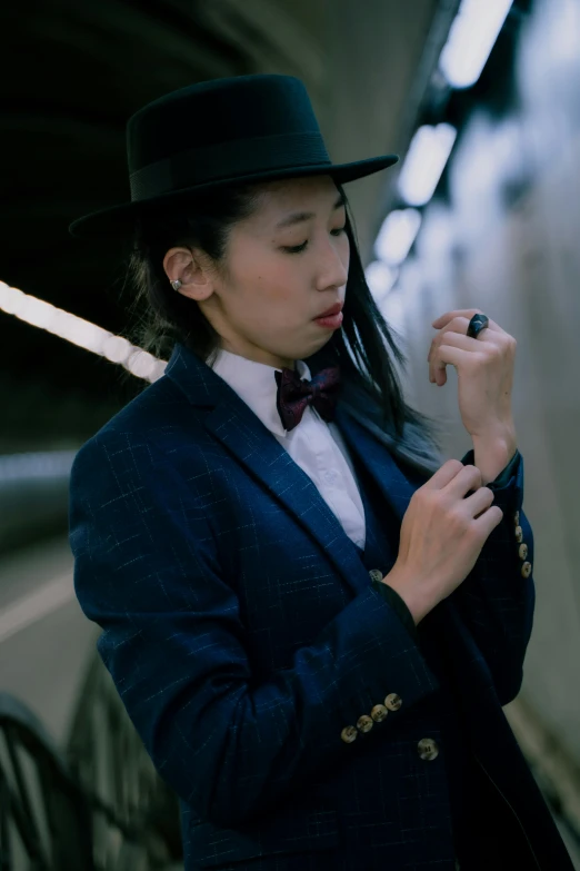 a young woman in a top hat and bow tie holding soing