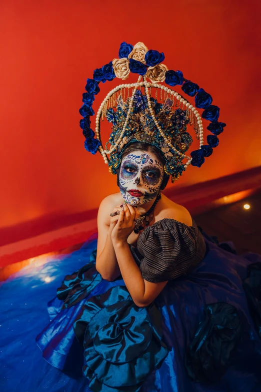 a girl in costume with face paint is laying on the ground