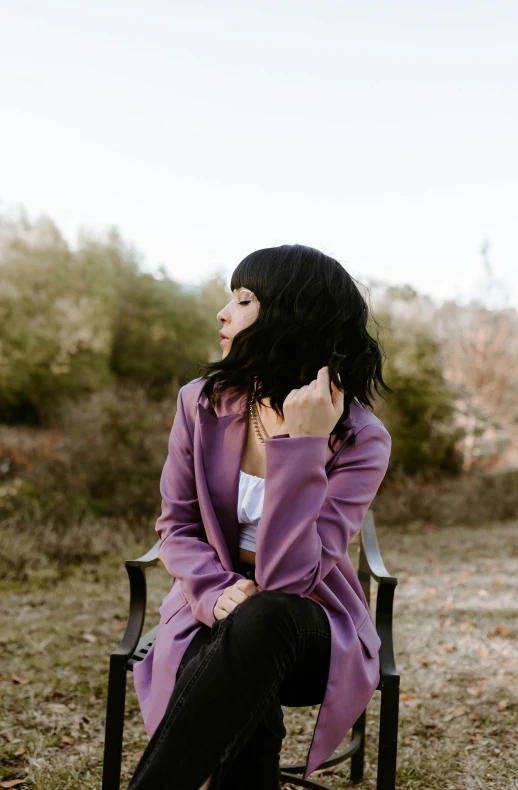 a woman is sitting on a bench outside