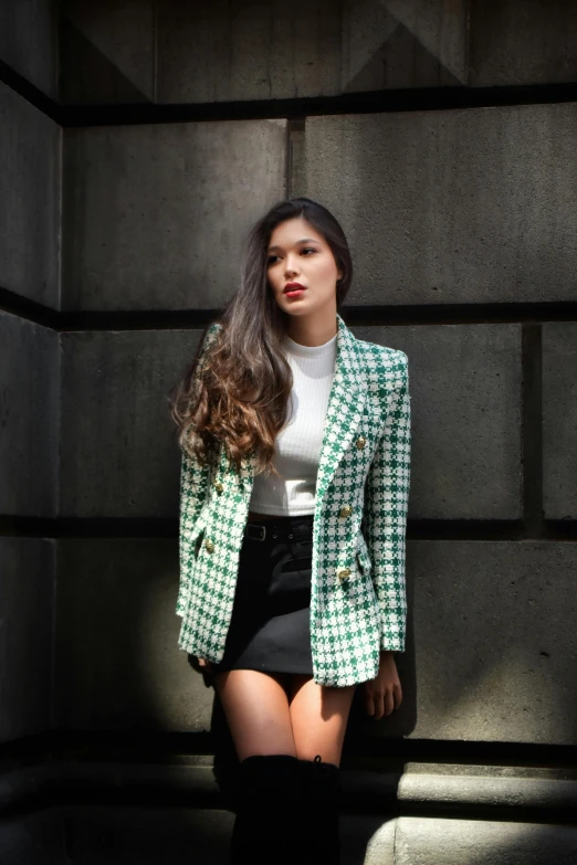 the woman is posing by the wall with her hair wet