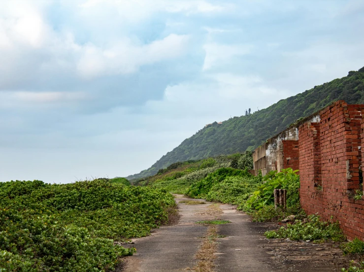 an abandoned building along side a dirt road