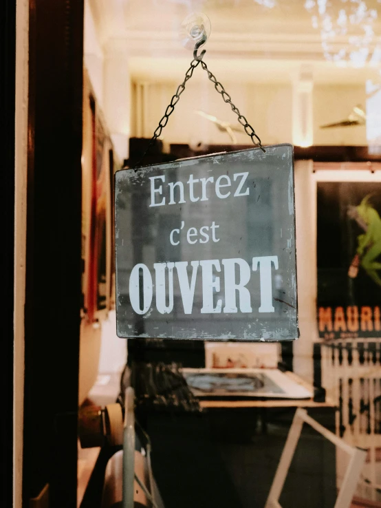 a sign is hanging from the front of a shop window