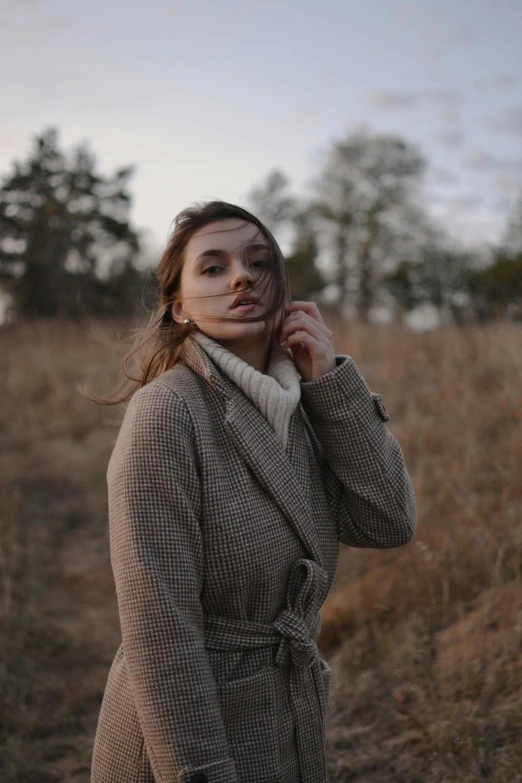 woman with freckled hair looking ahead wearing coat