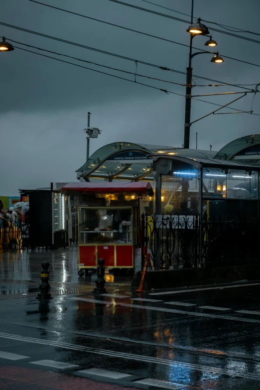 the city trolley is stopped at a rainy station