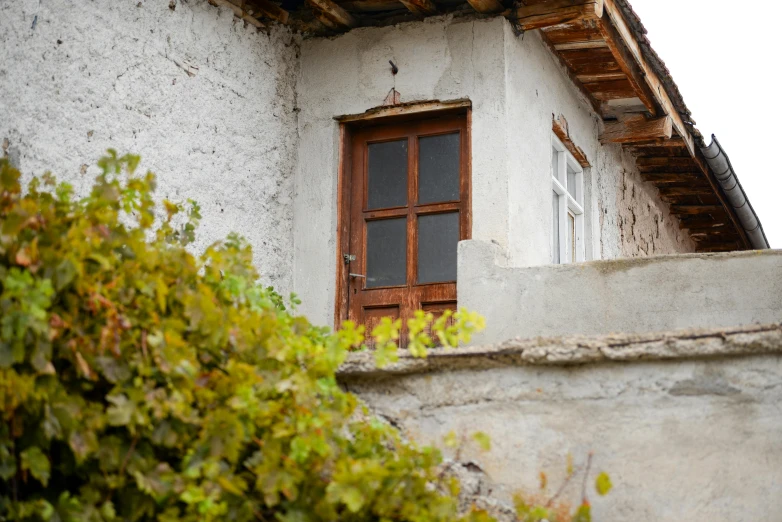 a window on an old, rustic white house