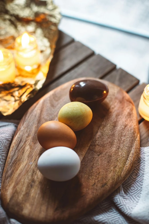 several eggs in a row on a tray next to candles