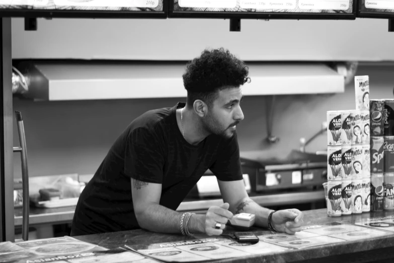 a man sitting at a counter in a restaurant looking over the menu