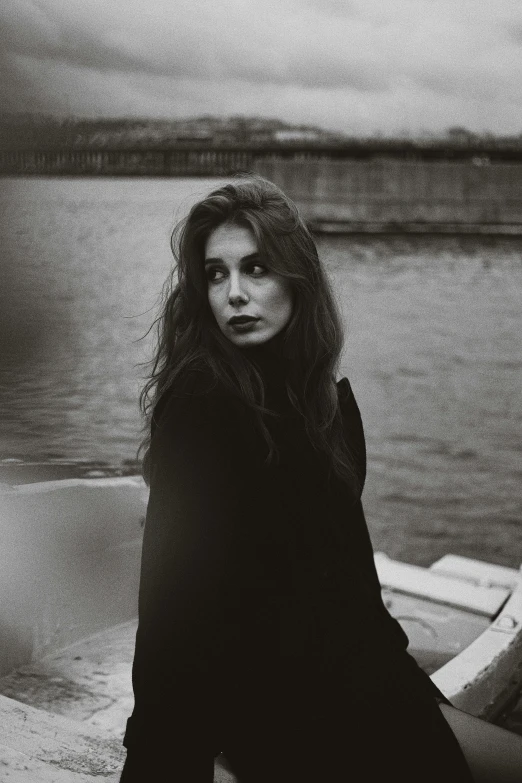 a woman sitting on top of a boat near water