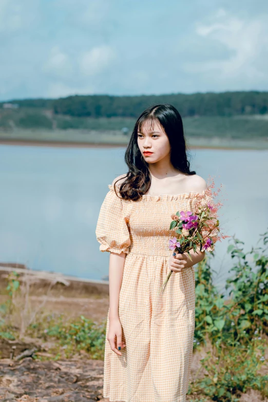 a young woman is posing for a picture by the water