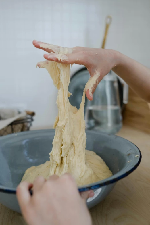 a person mixing some batter into a blue bowl