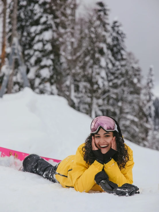 smiling female skier on snowy mountain with trees in background