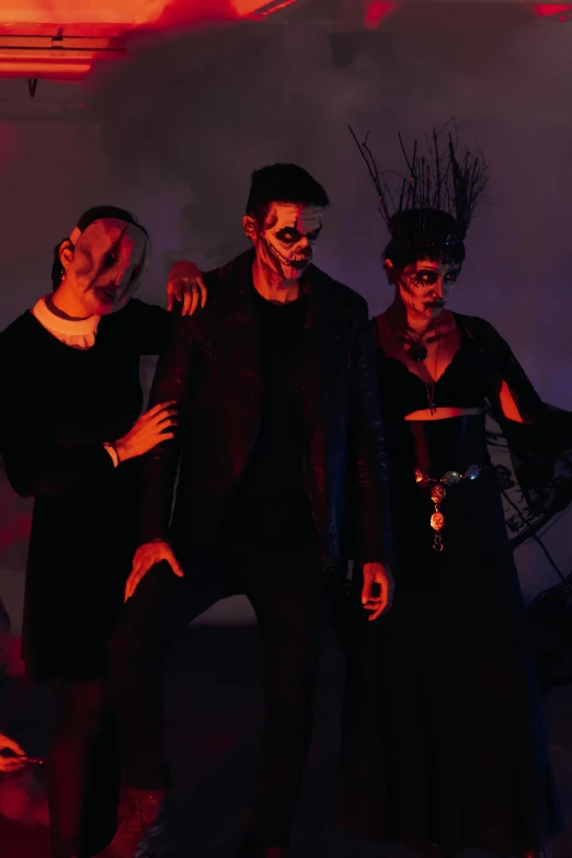 four people in black clothing are posing for the camera