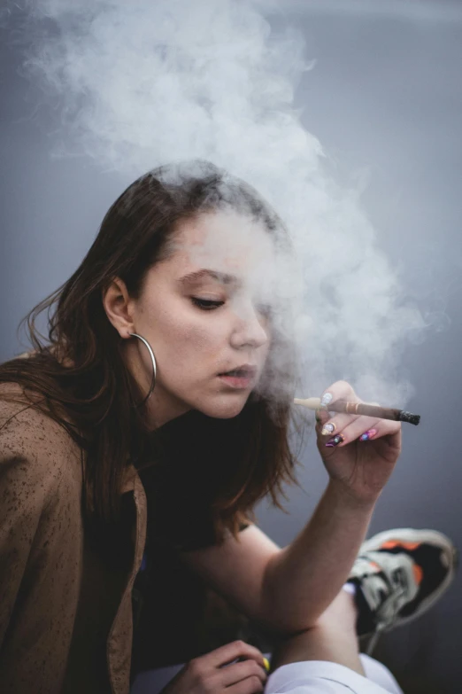 a woman sits in front of a smoke cloud