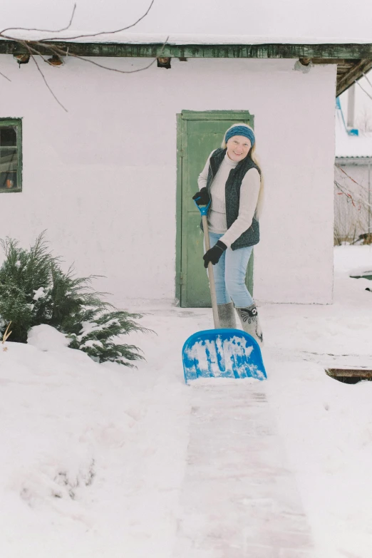 a snowboarder is standing in the snow next to a house