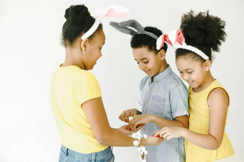 three children standing together with a couple of buns on their heads