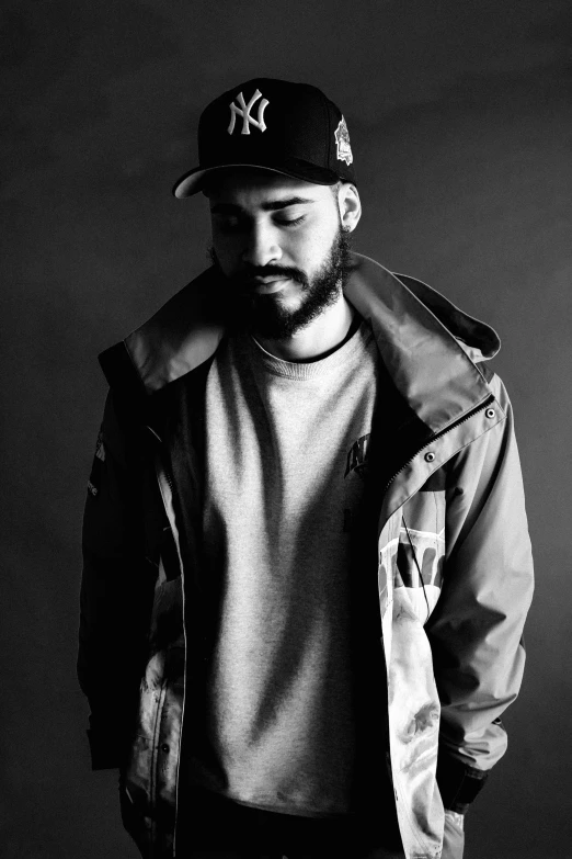 a young man in a baseball cap and jacket posing for the camera