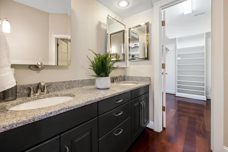 an empty bathroom with double sinks and large mirror