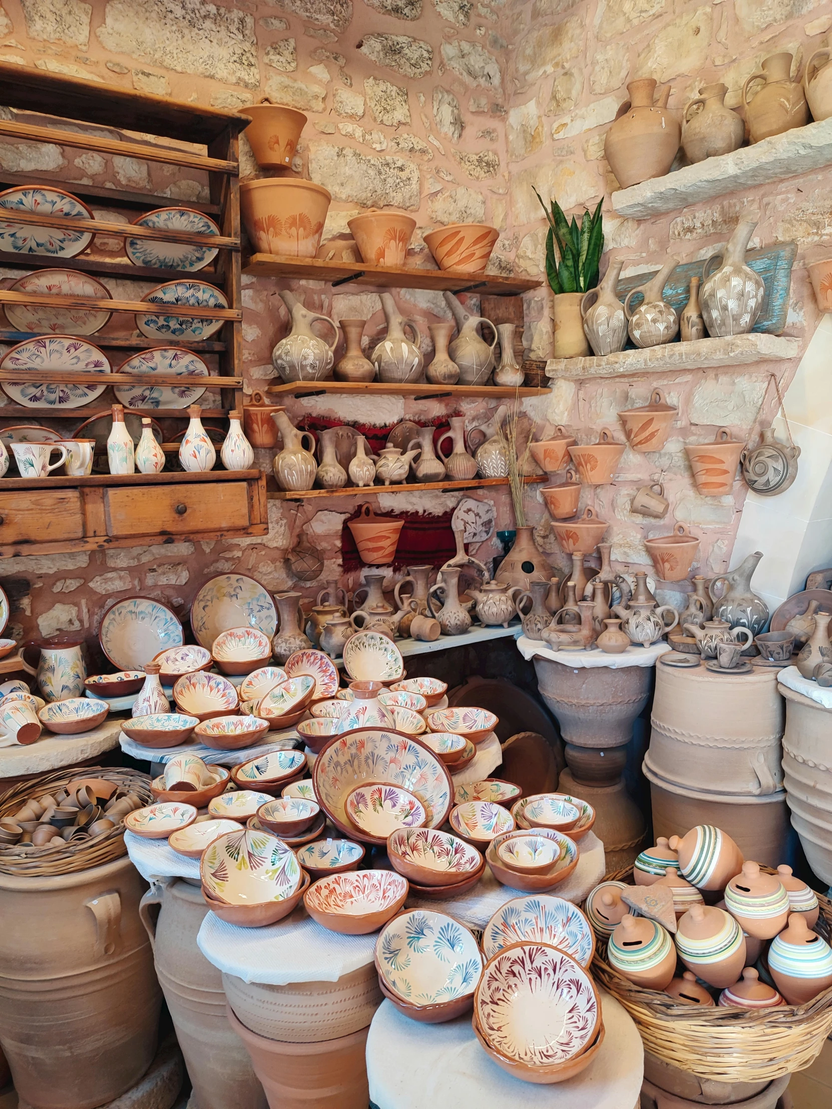 a number of pottery pots and dishes in a room