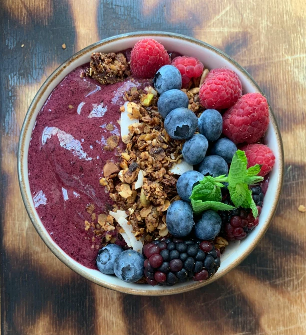 a bowl of fruit and granola on a table