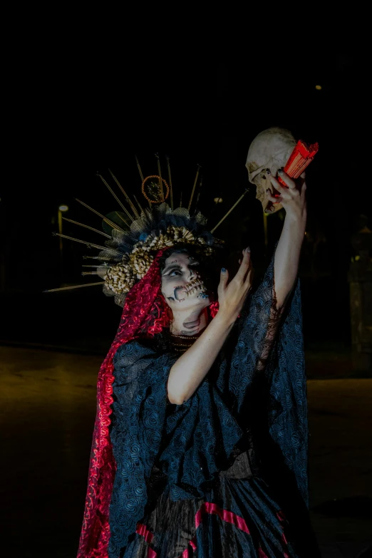 a person dressed in a costume holding a skull with makeup