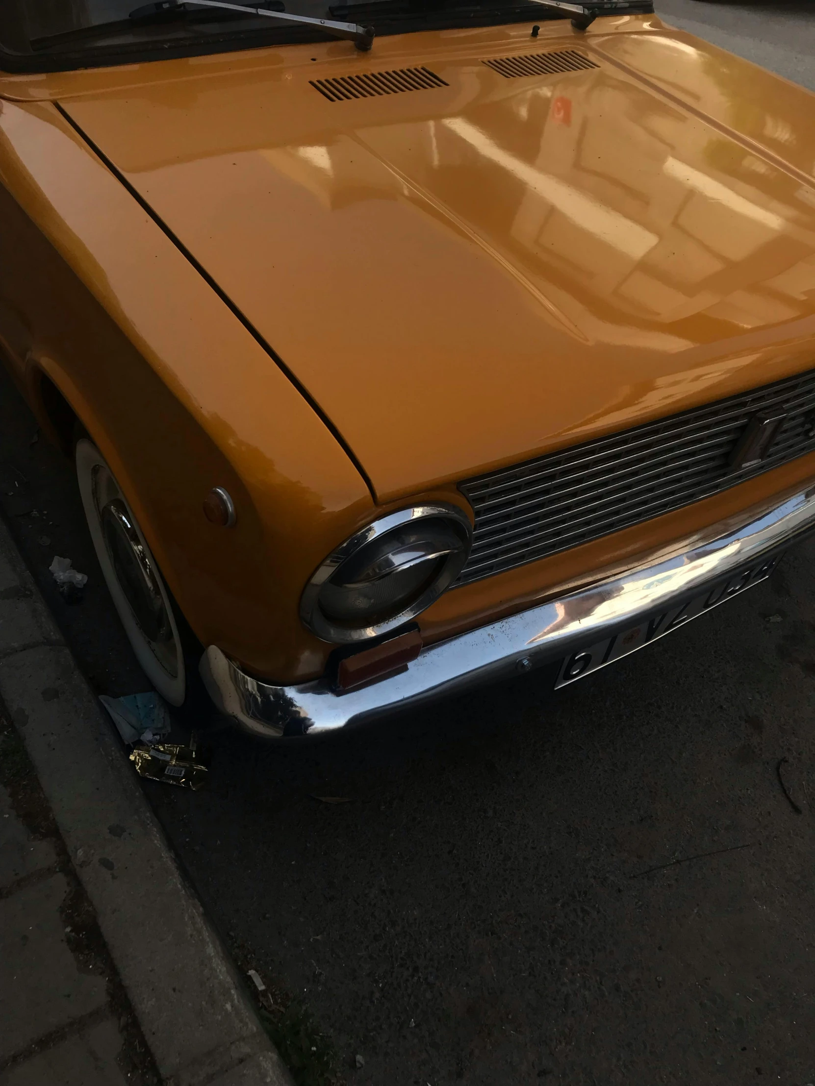 an orange car parked next to a street