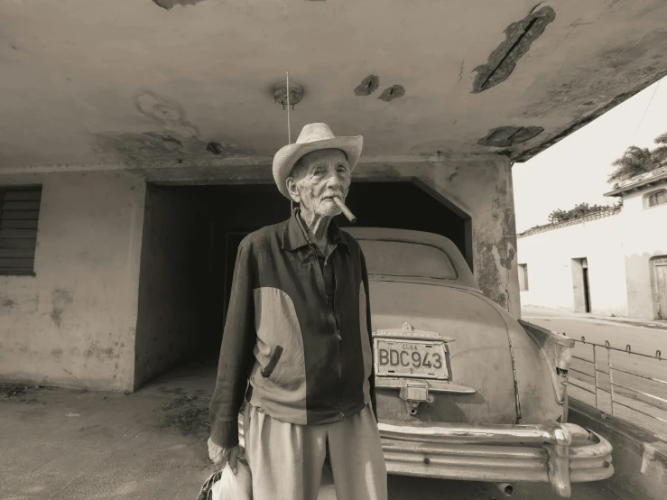 a man standing in front of an old car