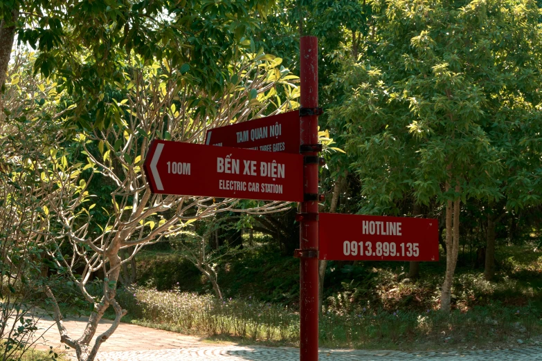 two signs that are on top of a red pole