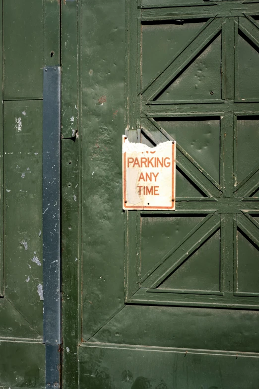 a sign on a green door says, parking only time