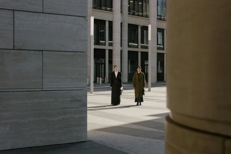 two people are walking through an empty courtyard