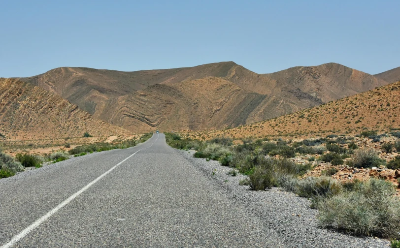 an empty road in the middle of the mountains