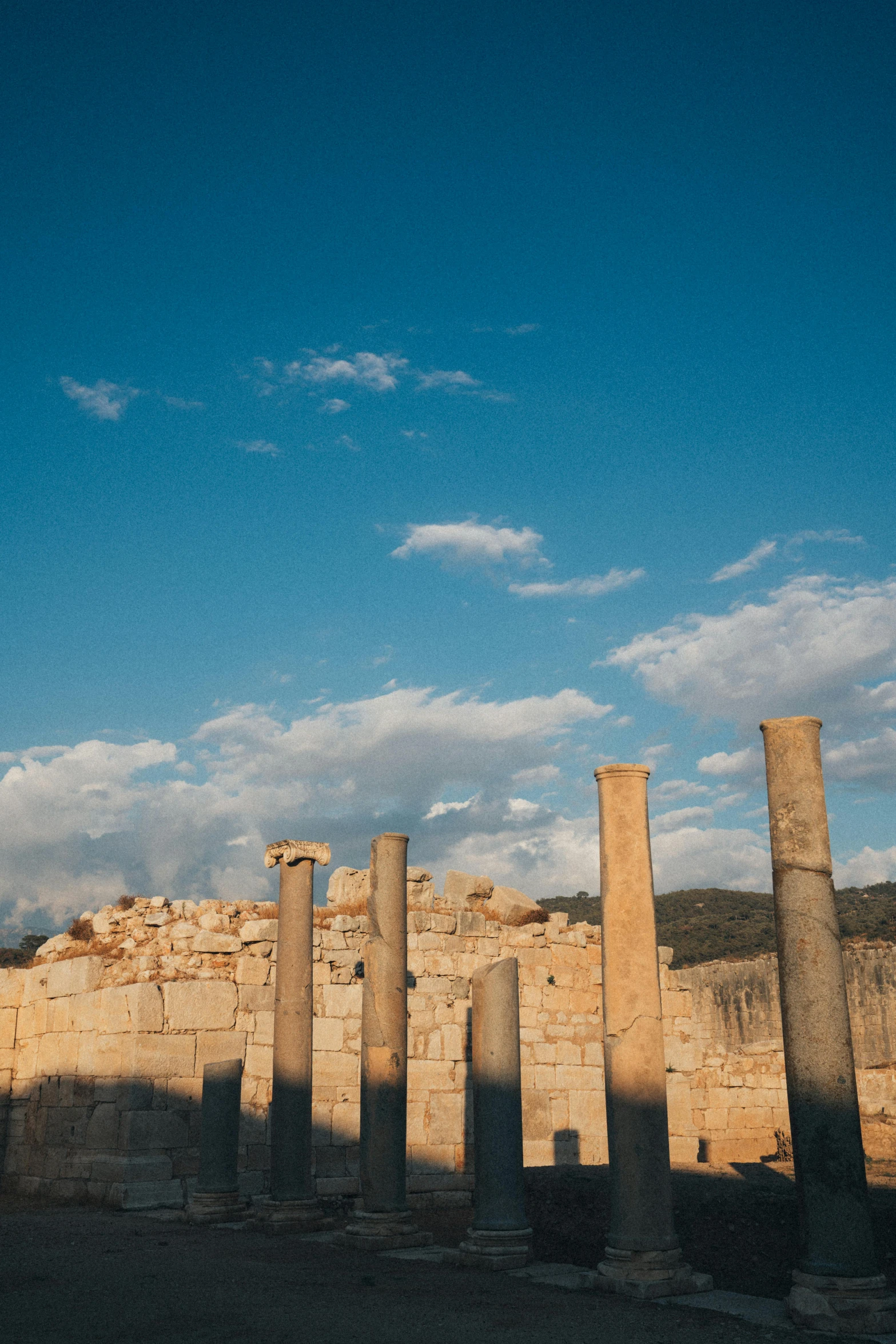 several tall stone pillars in front of a wall