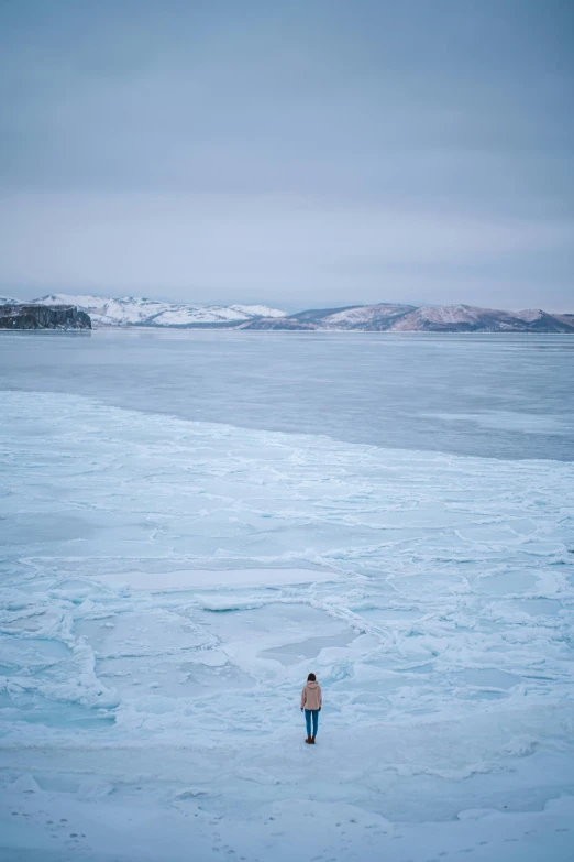 an older man walking through the ice of a frozen lake