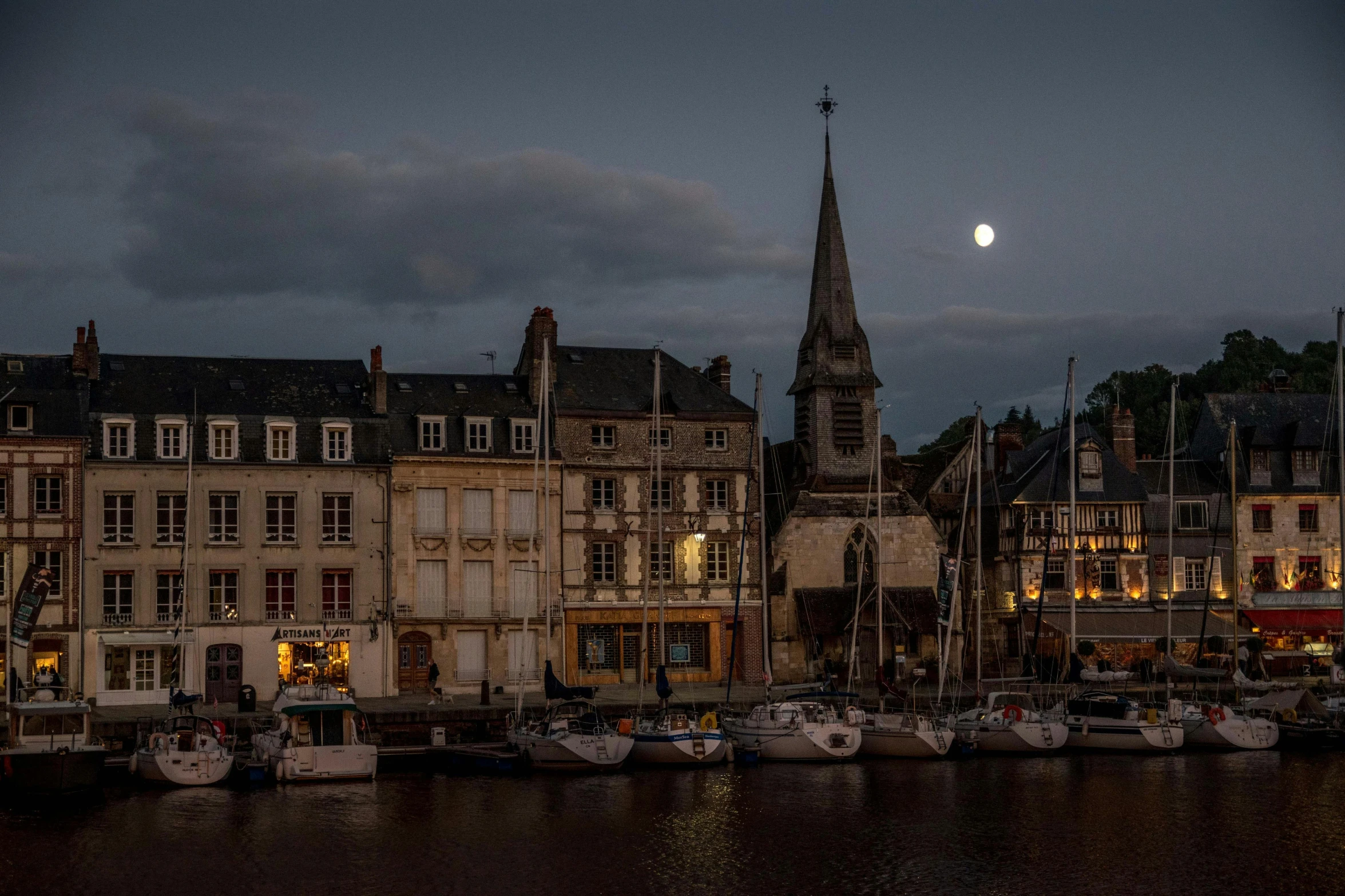 boats are parked at the dock with a clock tower in the background