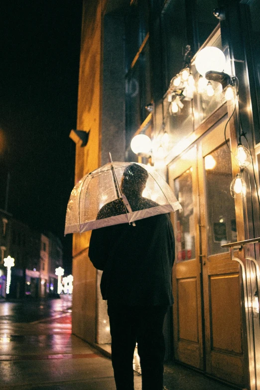 a person holding an umbrella under the night light