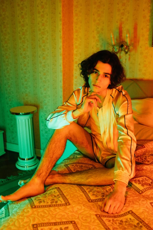 a young man is posing on his bed with a controller