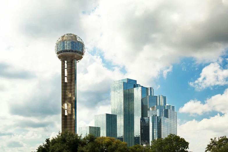 the tall tower has a large glass building near it