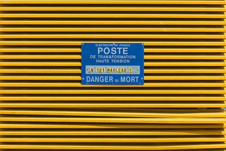 a sign is on the side of a yellow structure
