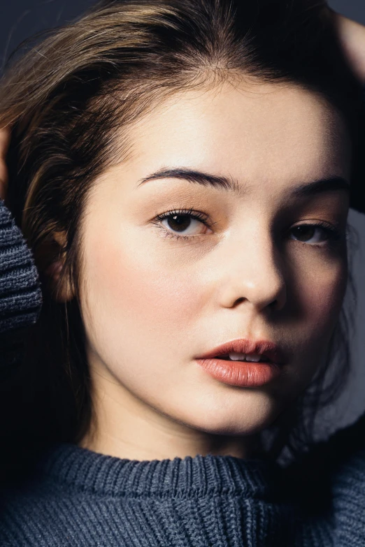 a young woman poses for the camera with her hair in a bun