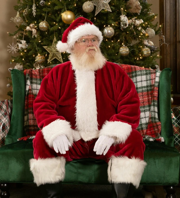 a man with a beard in santa clause suit sitting on a green chair